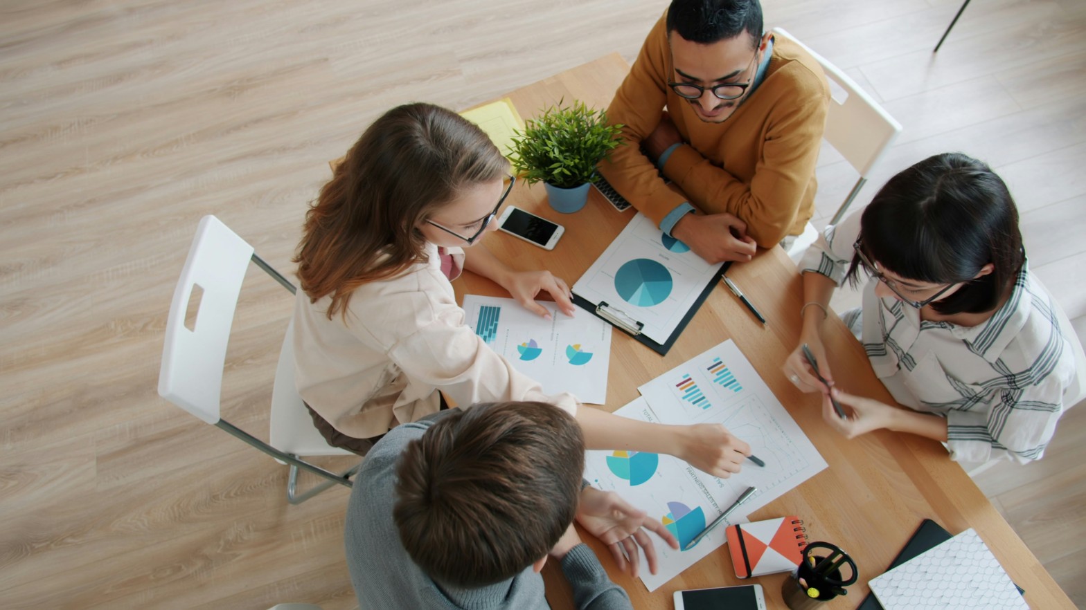 Students reviewing business charts around a table